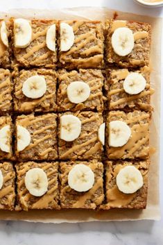 sliced bananas and peanut butter squares on parchment paper