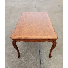 a wooden table sitting on top of a cement ground