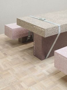 two stone benches sitting next to each other on top of a hard wood floored floor