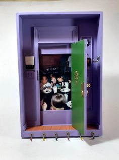 an open purple cabinet with children in it and one child looking at the camera from inside