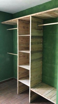 a room with green walls and shelves in the corner, all made out of pallet wood