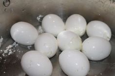 some white eggs are in a silver bowl