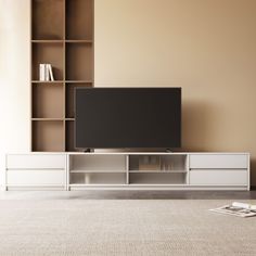 a flat screen tv sitting on top of a white entertainment center next to a book shelf