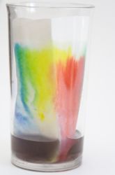 a glass filled with colored liquid sitting on top of a table