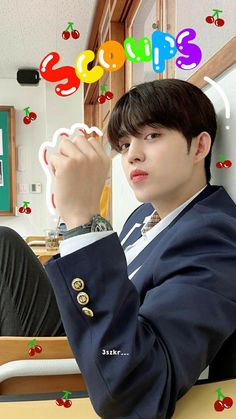 a young man sitting at a table with his hand on the top of his head