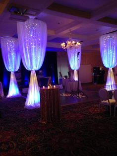 a room filled with chairs and tables covered in blue lights