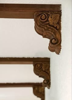 an ornate wooden shelf with two mirrors above it