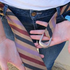 a person wearing a tie with their hands on the back of his pants while holding onto an object