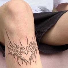 a woman's leg with a tattoo on it, sitting on the floor next to a bed