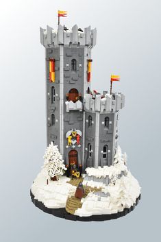 a castle made out of legos with snow on the ground and trees around it