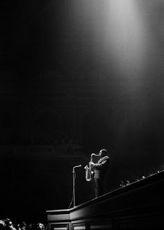 a man standing on top of a stage holding a microphone in front of an audience