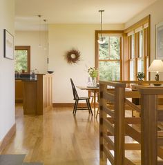 a dining room and kitchen area with wood floors