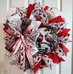 a red and white wreath with two birds on it's front door hanger