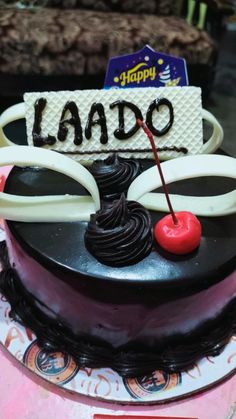 a birthday cake with chocolate frosting and a cherry on top that says happy lado