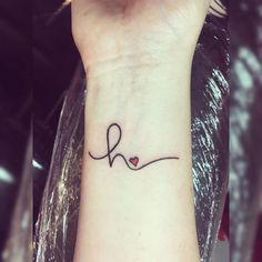 a woman's wrist tattoo with the word love written in cursive writing