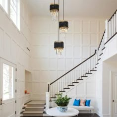 a living room with white walls and black carpeted flooring next to a stair case