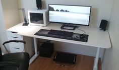 a computer desk with two microwaves and a keyboard