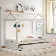 a child's bedroom with a white bed and pink toys on the floor next to it