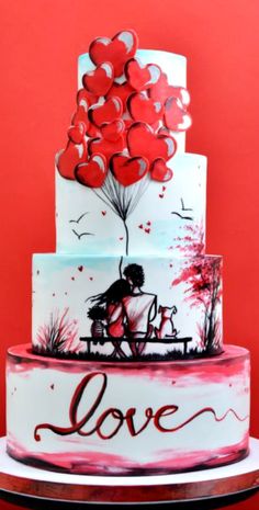 a three tiered cake decorated with hearts and a couple on a bench under a tree