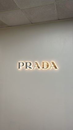 the words prada are lit up against a white wall