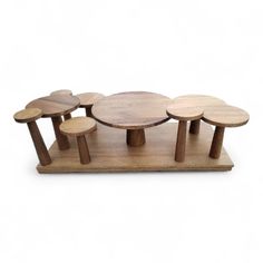 four wooden stools with different shapes and sizes on each one, sitting on a white surface