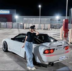 a man standing next to a white sports car