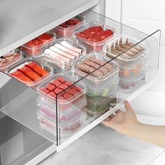 an open refrigerator door with food in containers on the bottom shelf and hand reaching for it