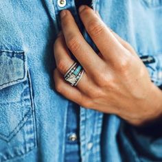 a person wearing a denim shirt and ring