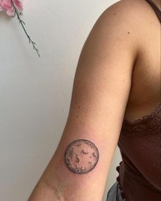 a woman's arm with a small tattoo of the moon and stars on it