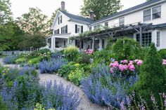 a house with lots of flowers in front of it