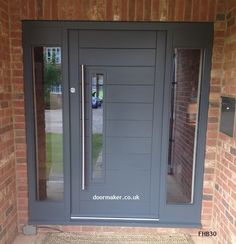 a grey front door with two sidelights and glass panels on the outside of it