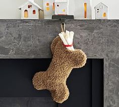 a stuffed animal is hanging from a fireplace mantel with candles on it and houses in the background