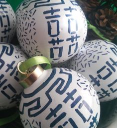 an ornament with chinese writing on it is sitting in front of some pine cones