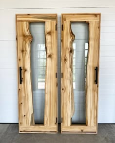 two doors made out of wood with glass panels on the front and back sides, both side by side