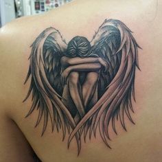 an angel tattoo on the back of a woman's shoulder