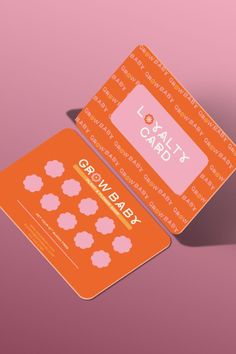 an orange and pink business card sitting on top of a purple surface with the words, cal