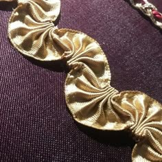 a close up of a necklace on a purple surface