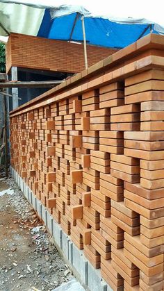 a building made out of wooden planks with a blue tarp on top