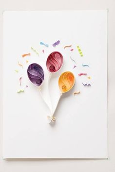 three colorful lollipops with confetti and streamers on top of them