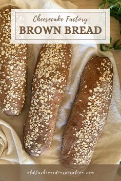 three brown breads sitting on top of a white cloth