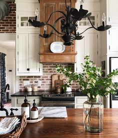 a chandelier hanging from the ceiling in a kitchen next to a wooden table