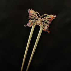 "This is an adorable gold metal u shaped hair fork featuring a vibrant gold metal butterfly, with rainbow colored enamel wings, featuring clear white faceted jewels that sparkle and change color in the light. The whole fork is 4 2/3\" long, with the prongs being 3 1/2\" long, and 2\" wide. Make sure to check out my shop for more brooches, hair pins, jewelry, accessories, and all sorts of fun stuff! Colorful Butterfly, Jeweled Butterfly, Butterfly Hair Fork, Butterfly Hair Stick, Sparkling Butter Maximalist Jewelry, Butterfly Rainbow, Hair Accessories Bun, Octopus Jewelry, Silver Hair Comb, U Shaped Hair, Butterfly Butterfly, Metal Butterfly, Hair Fork