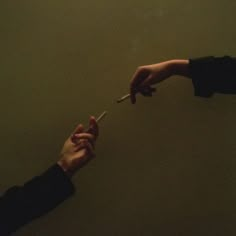 two people reaching out towards each other with one hand holding the other's finger