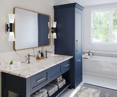 a bathroom with blue cabinets, marble counter tops and white tile flooring is shown