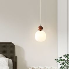 a bedroom with a bed, plant and hanging light in the corner on the wall