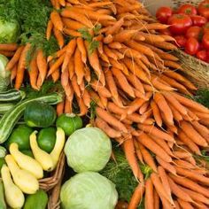 many different types of vegetables on display in baskets and at the same time, including carrots