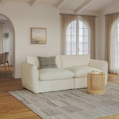 a living room with white furniture and windows