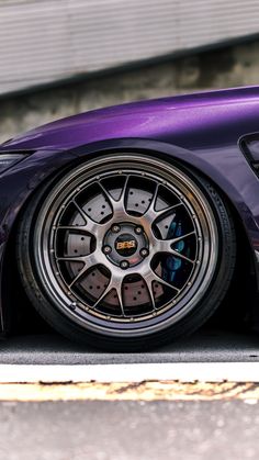 a purple sports car parked in front of a building