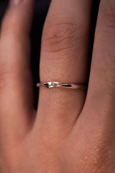 a woman's hand with a silver ring on top of her finger, showing the band