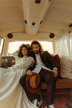 a man and woman are sitting in the back of a van with their arms around each other